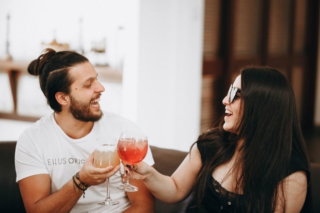 Fun Questions To Ask A Guy - man and woman toasting their drinks