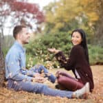Happy couple scattering leaves in park - Featured