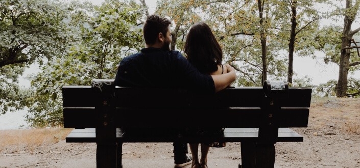 romantic moment of couple while sitting on bench