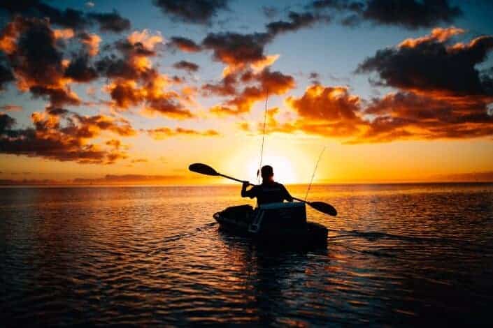 silhouette of person riding a boat