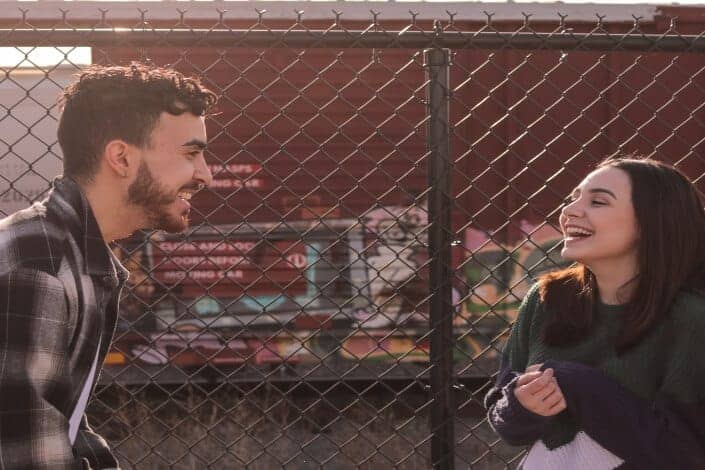 man talking to woman near a fence