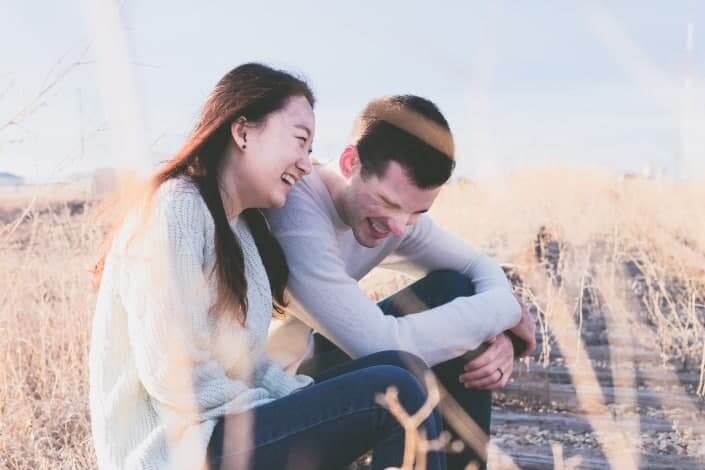 man and woman laughing during daytime