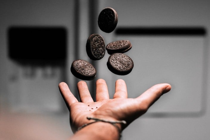Guy tossing five Oreos