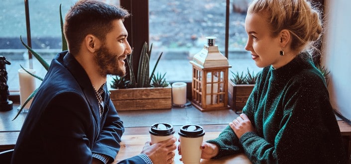 Couple staring into each other's eyes over coffee