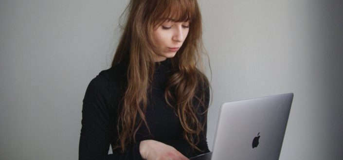 A woman seriously typing on her laptop
