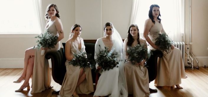 Bride and bridesmaid posing for photo on couch