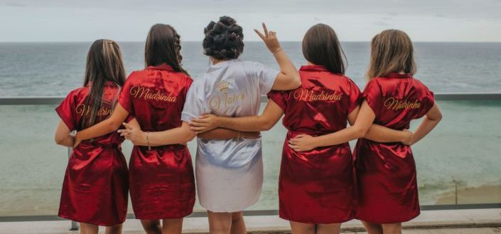 Bride and bridesmaid linking arms together for a photo