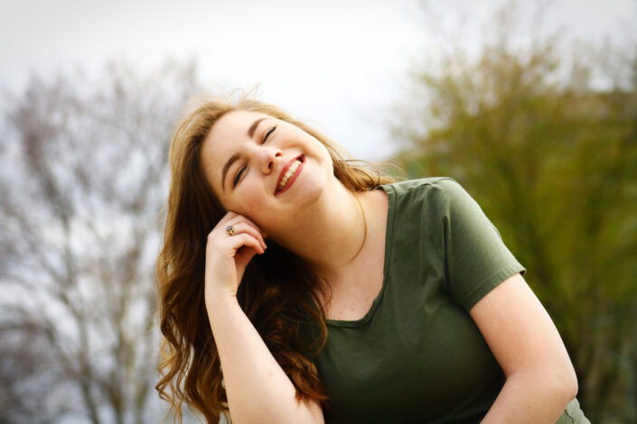 Girl in green shirt feeling emotionally happy.