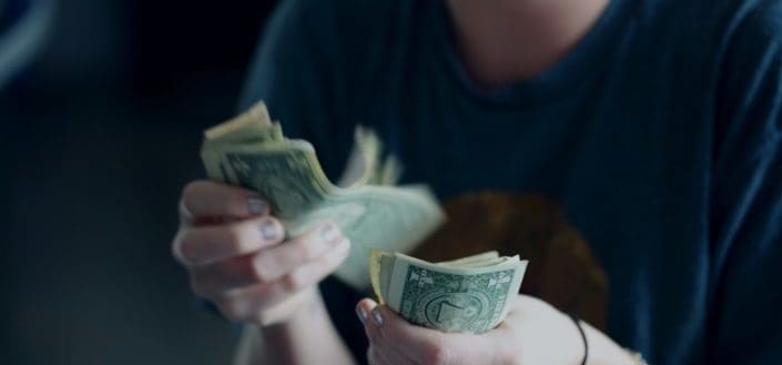 Cropped woman counting dollar bills