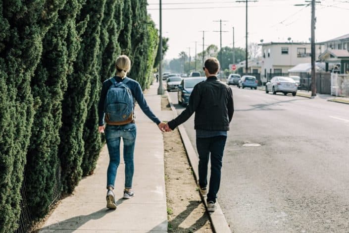 couple holding hands while walking 