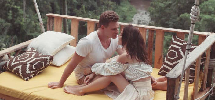 Couple enjoying sweet moments on a cozy bed swing