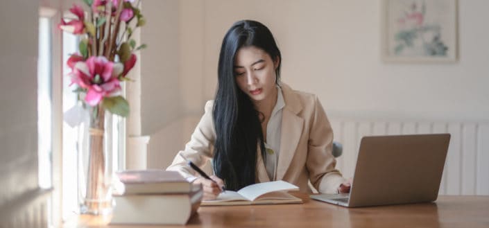 girl looking at a book while working