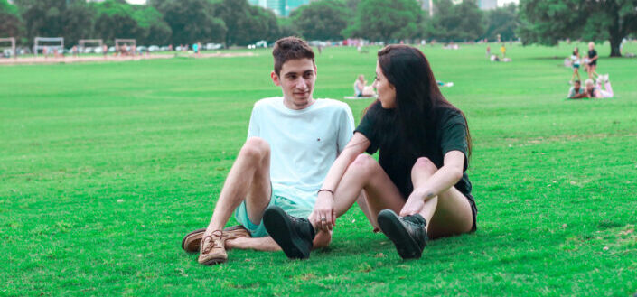 young couple resting on lawn in park