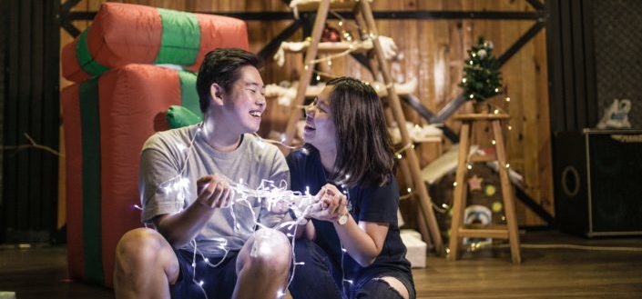 Couple sitting while holding their christmas lights