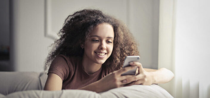 curly woman texting in her phone