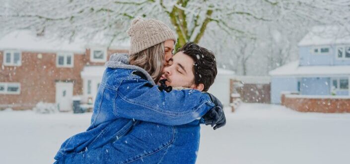 Couple romantically hugging under the snowy weather