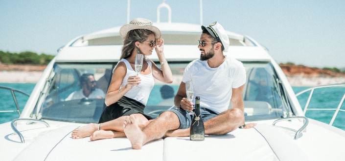 couple sitting in a yacht while drinking wine