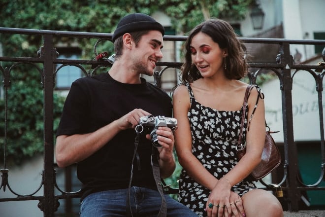 Questions to ask your crush - man holding camera and woman talking to him