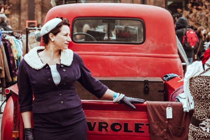 Vintage woman standing behind a car's trunk