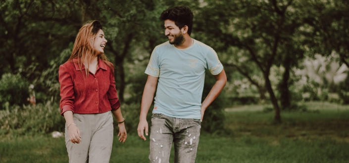 A woman and a man walking while laughing