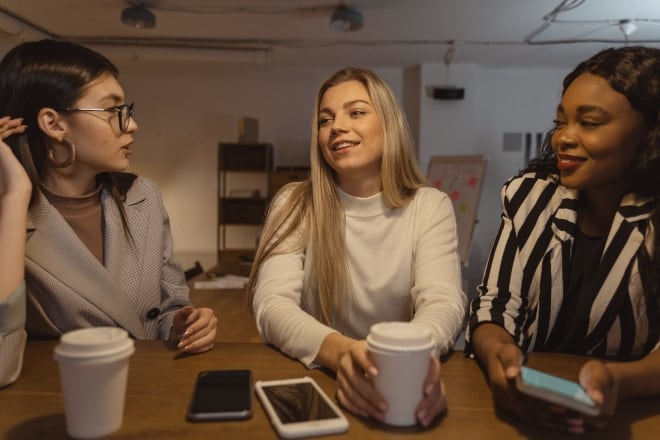 Three women talking to each other - questions to get to know someone