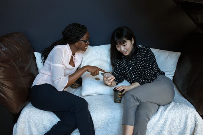 Two women on a couch talking