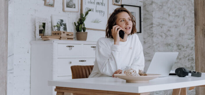 Girl talking on a phone with laptop.