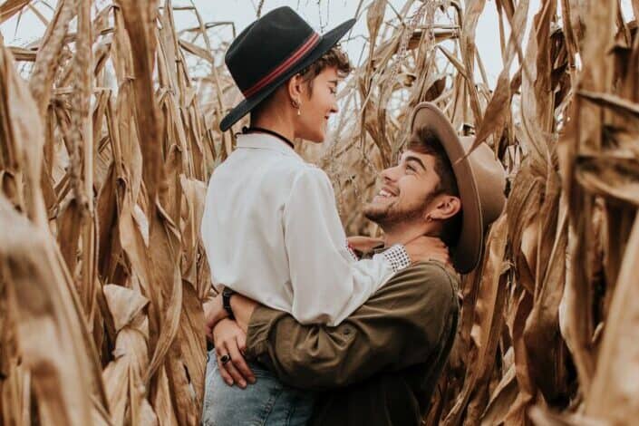 Guy lifting up a girl in a field.