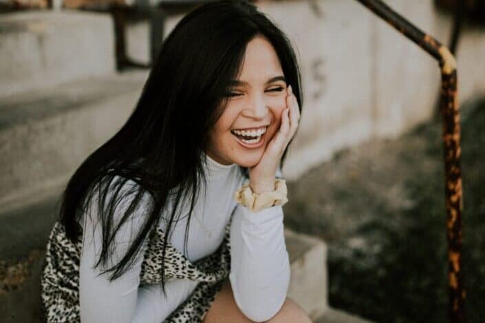Girl laughing with her hand on her face