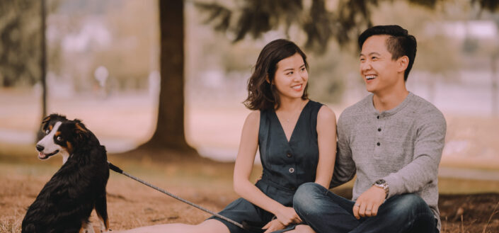 Asian couple with dog resting in a park