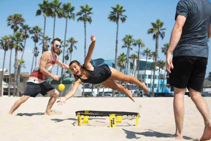 Girl diving for ball on beach