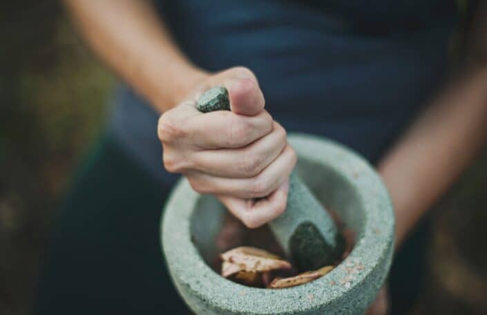 a person grinding spices using mortar and pestle