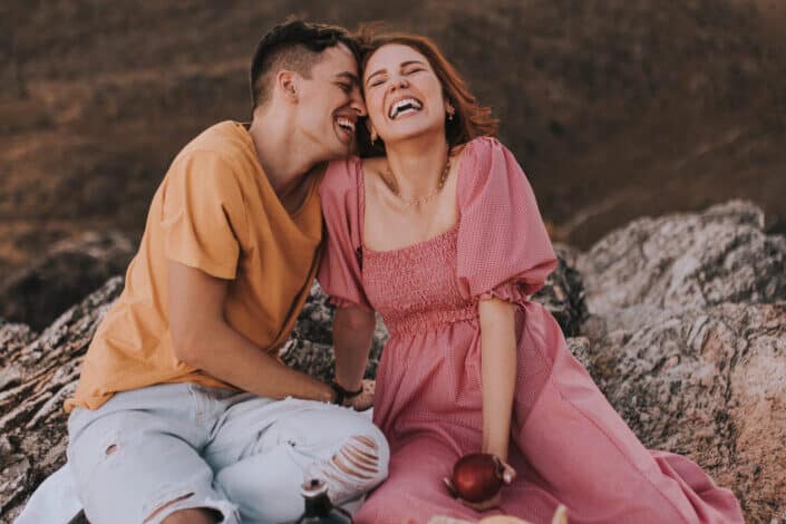 Laughing couple with closed eyes in mountains