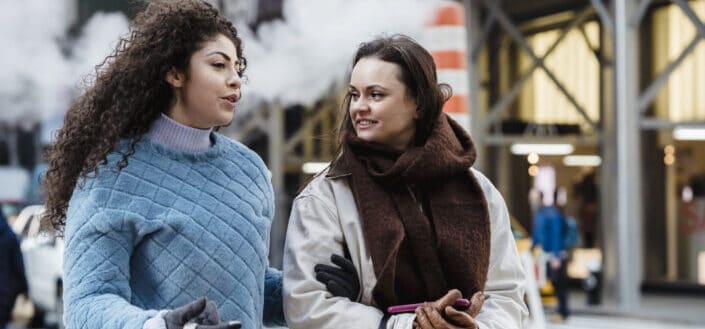 two ladies having a walk and a chat in a cold street 