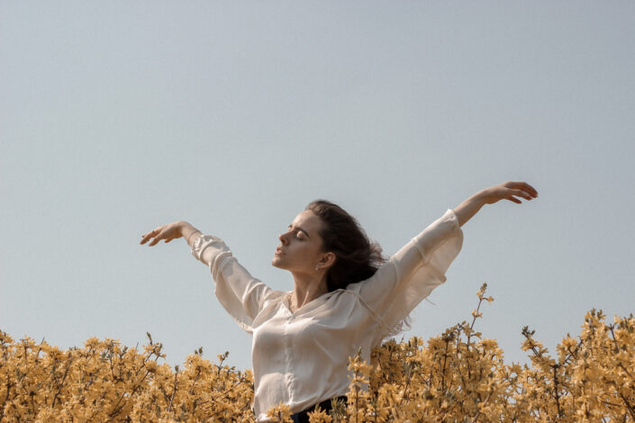 a carefree woman enjoying the breeze under a clear sky