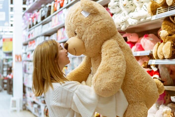 woman carrying life size bear plush toy