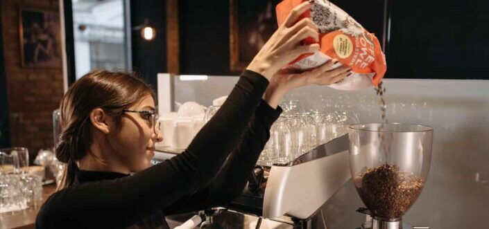 Lady barista tending a coffee mixture