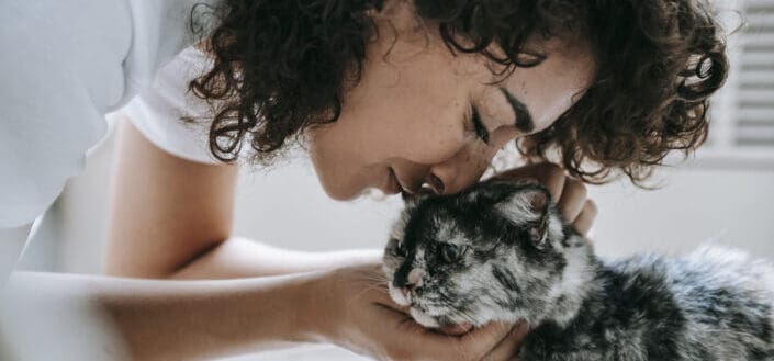 Woman touching cat with nose