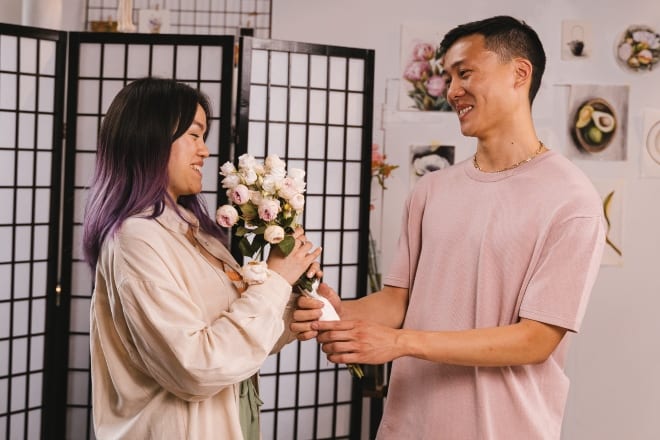 Man Giving His Girlfriend Bouquet of Flowers - signs he likes you