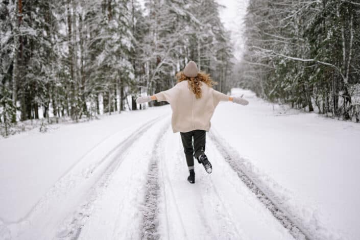 Happy woman running thru the snow 