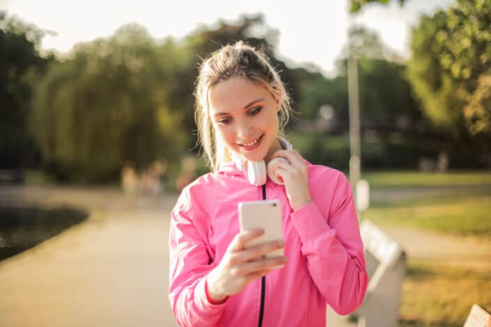 Woman looking at her phone after finishing morning jog