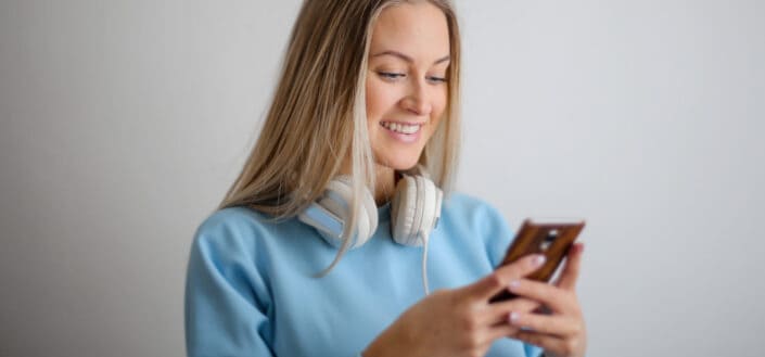 Blonde woman smiling at her phone