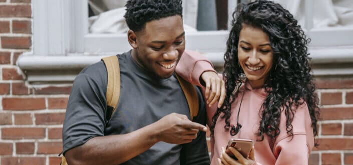 Man and woman smiling over something in the phone