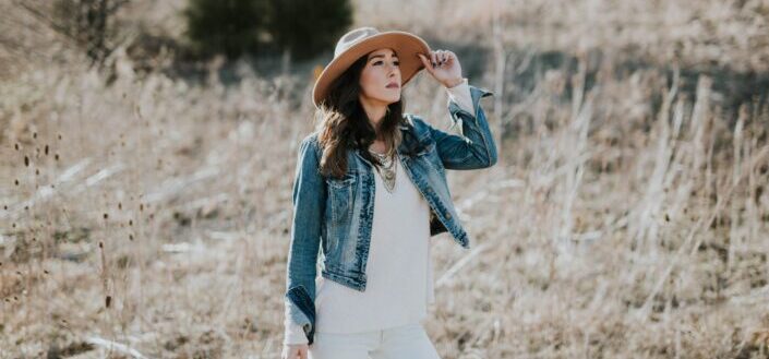 Lady in cowboy hat in the middle of a dry field