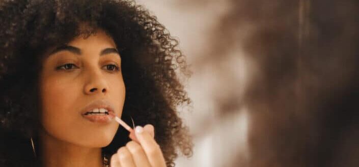 Woman putting on some lipgloss