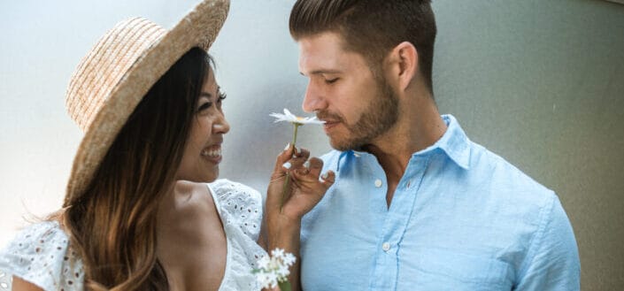 Woman letting her man to smell flower