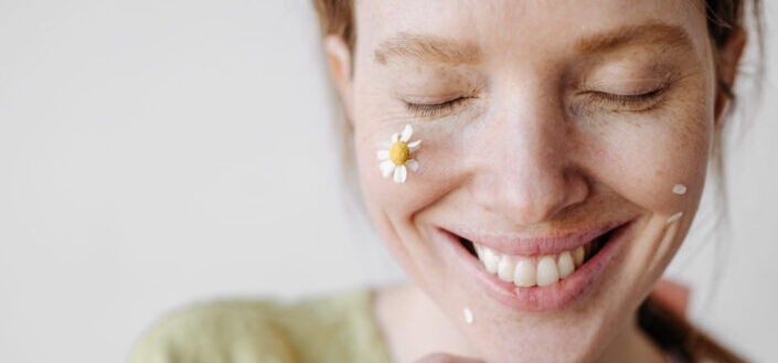 Smiling woman with small flowers on her face