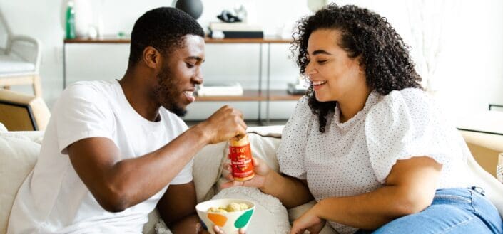 man and woman sharing a snack at home
