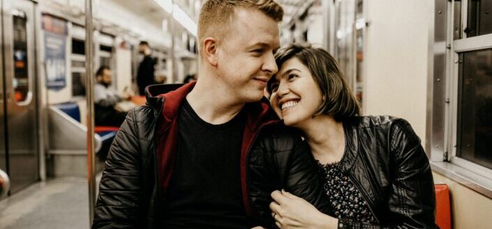 woman hugging man while sitting inside a train