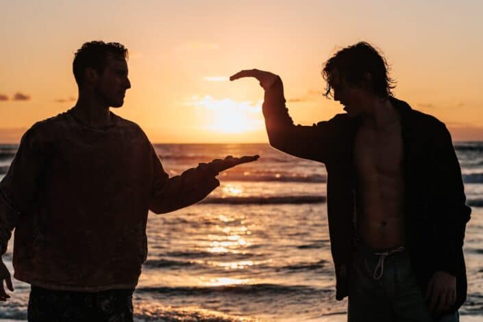 A silhouette of two guys doing a secret handshake.